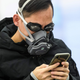 A passenger wears swimming goggles and a facemask as he waits inside the high-speed train station connecting Hong Kong to mainland China on January 28, 2020